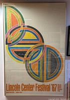 Full view of framed lithograph poster featuring overlapping colored circular arcs and title 'Lincoln Center Festival '67'. Gold metal frame visible.