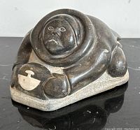 Front view of Inuit figure with hooded parka holding ulu inset