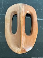 Front view of the oval terracotta mask showing central ridge and eye openings