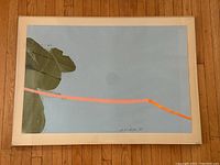 Full view of framed artwork on hardwood floor