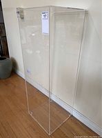 Front view of tall clear acrylic pedestal stand.