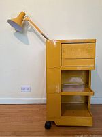 Full front view of yellow Bobby Trolley on wheels with attached lamp