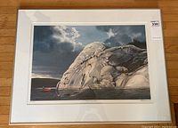 Framed print showing full composition of rock, water, sky, and canoe