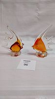 Pair of art glass angelfish figurines side by side on white fabric background with lot card