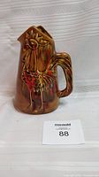 Photo of front and side view showing the rooster design on ceramic pitcher and handle