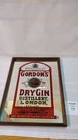 Front view showing the red, gold, and mirrored sign with Gordon's Dry Gin branding and logo including a red boar emblem, text and estd 1769.