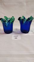 Pair of dark blue art glass vases with green/turquoise tips, front view.