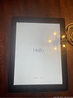 Apple iPad turned on showing a 'Hello' setup screen with black bezel and home button.