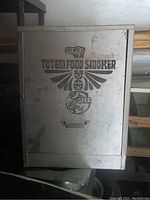 Exterior view of the Totem Food Smoker unit, shows embossed logo and handle on front door.