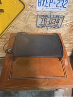 Full view of the black rectangular electric griddle sitting on a wooden surface, showing the cooking surface and power cord with temperature control.