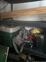 Shelf with fishing and boating equipment including cooler, tackle bag, minnow bucket, fishing reel, tip ups, boat seat adapters.