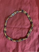Full magnetic bead jewelry laid in a circular form showing the alternating pattern of wooden and magnetic beads.