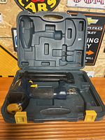 Open carrying case showing blue and black Mastercraft brad nailer with yellow trigger inside the molded interior.
