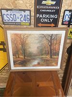 Framed canvas print showing the autumn landscape and frame detail.
