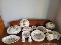 Photo showing full set including plates, tureen with lid, salt and pepper shakers, cream jug, covered butter dish, and several bowls, all with Gainsborough floral pattern.