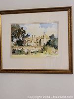 Framed watercolor painting showing a large house with garden and sky background