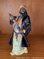 Front view showing Blue Beard figurine holding sword, detailed clothing and posture.