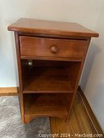 Front view of wooden nightstand showing drawer and two shelves