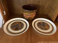 Photo showing two ceramic plates and one vintage ceramic vase with burnt orange glaze