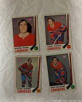 Front sides of four vintage 1969-70 O-Pee-Chee hockey cards featuring Montreal Canadiens players Rogatien Vachon, Terry Harper, Jacques Laperriere, and Ralph Backstrom.