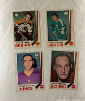 Front of four 1969-70 O-Pee-Chee hockey cards featuring Dallas Smith, Tom Polonic, Brent Hughes and Doug Mohns.