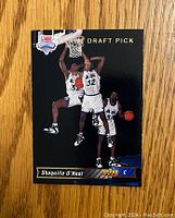 Front of the Shaquille O'Neal 1992-93 Upper Deck rookie card showing action shots and draft pick designation.