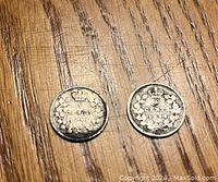 Two 1899 Canadian 5 cent silver nickels showing the reverse side with denomination and wreath design