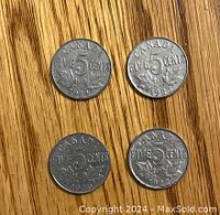 Obverse and reverse sides of four Canadian 5 cent nickel coins dated 1922, 1923, 1924, and 1925, displayed on a wooden surface.