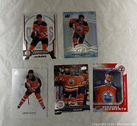 Front of five Connor McDavid hockey cards laid out, showing different Upper Deck series with Edmonton Oilers imagery.