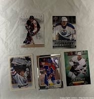 Front side of five Wayne Gretzky hockey cards featuring different styles and years.