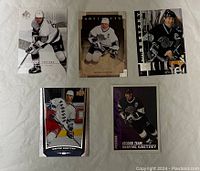 Front side image of five Wayne Gretzky hockey cards laid out on flat surface in various team uniforms and series