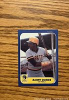 Front image of Barry Bonds rookie baseball card showing player batting in Pirates uniform with blue border and yellow nameplate.