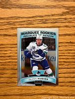 Front of Quinn Hughes hockey card showing player in Vancouver Canucks uniform with Marquee Rookies title.