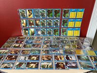 Full spread of multiple E.T. The Extra-Terrestrial 1982 movie trading cards laid out on a flat surface, showing front sides with images from the film.