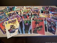 Overhead shot of multiple WILDC.A.T.S Covert Action Teams comic book issues spread out on a surface, showing colorful covers and variety of issues.