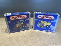 Two sealed Meccano construction sets side by side showing front packaging with Meccano logo and models 201 and 101.