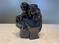 Front view of the black ceramic statue showing the couple reading a book