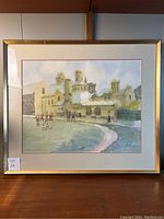 Framed watercolour painting depicting a university college building with figures on the lawn.