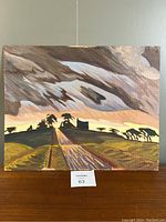 Front view of acrylic painting on board showing rural landscape with a central road, silhouetted trees, and farmhouse under a dramatic sky