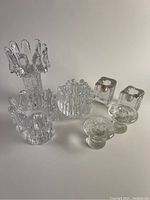 Overview of all five candle holders showing clear Swedish crystal and various designs including sunflower, Polar, and floral etched patterns.