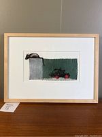 Framed modernist print showing mouse on textured shapes with red roller skate wheels.