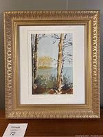 Full view of the framed original watercolour painting showing the Canadian landscape with birch trees and lake surrounded by gold gilt frame.