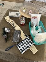 Photo showing beige bungee cords, small patterned pouch, clear plastic organizer, crystal votive candle holder, and turquoise plastic shower caddy with various small bathroom accessories inside.