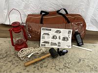 Overall lot items including Eureka tent in carry bag, red oil lantern, rope, oil bottle, rubber mallet, headlamp, instructions.