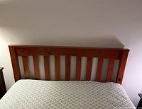 Front view of the full-size wooden headboard attached to the mattress.