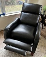 Black faux leather recliner fully extended with footrest out