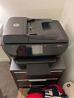 Front view of the HP ENVY 7640 printer showing paper output tray and control panel with touchscreen.