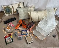 Overview photo showing thirty-plus items including the three decorative pillows, white mesh desk organizer, hole punch, glue gun, book series box, ice grips, picture frame, string lights, and various small office supplies.