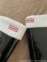 Close-up of upper part of boots showing white knit cuffs with Hunter logo patches