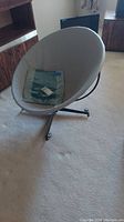 Full view of grey vinyl bucket chair on black metal swivel base with teal cushion